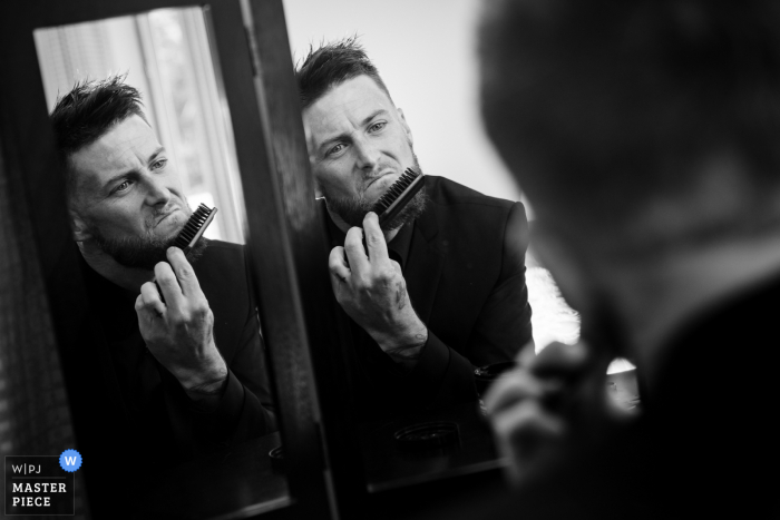 Fotografía de la boda de Pennsylvania del novio peinándose la barba en los preparativos finales para la ceremonia