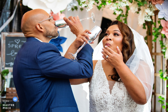 Wedding photography from Bergenfield, New Jersey of the bride and groom toast during NJ backyard wedding 