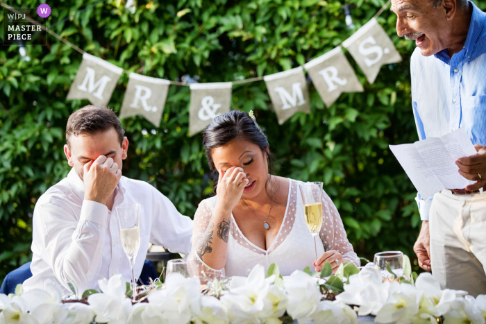 Fotografia de casamento de Nova Jersey - os noivos têm a mesma reação que os brindes do pai da noiva durante um casamento no quintal de Nova Jersey