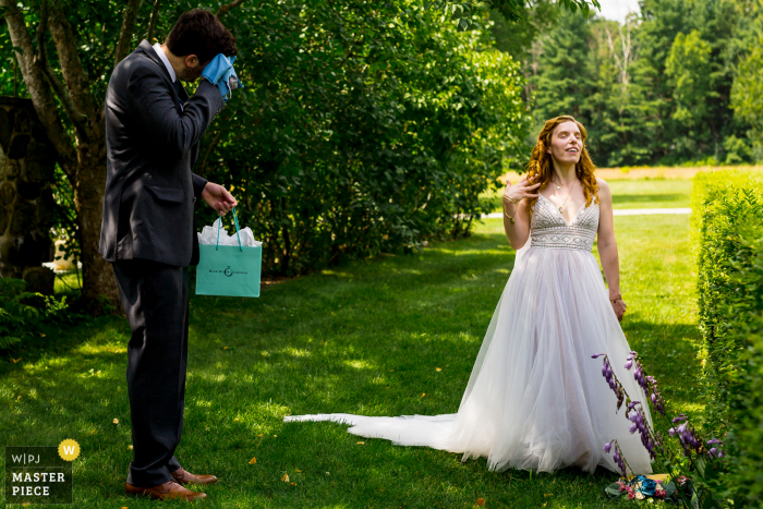 Wedding photograph from Andover, Massachusetts - the bride jokingly fans herself to mock the sweating nervous groom 