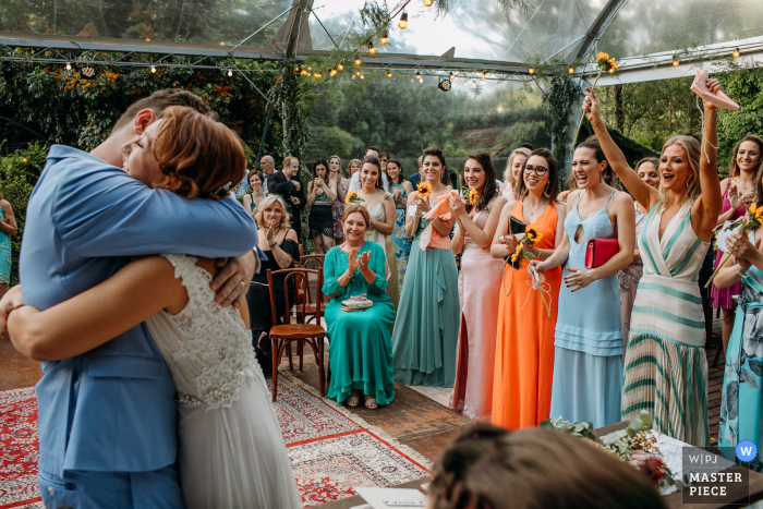 Trouwfoto van Rio Grande do Sul van de bruid en bruidegom die knuffelen onder een duidelijke tentceremonie