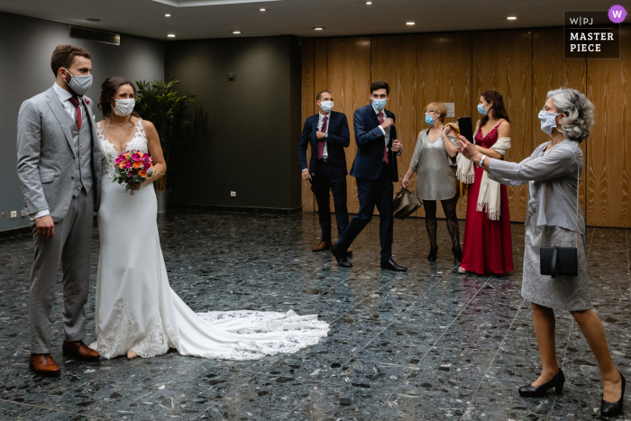 Casal de noivos franceses tirando fotos enquanto espera o início da cerimônia