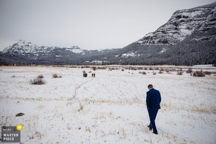 Yellowstone Winterhochzeitsbild des Bräutigams, der in Richtung des Zeremonienortes geht