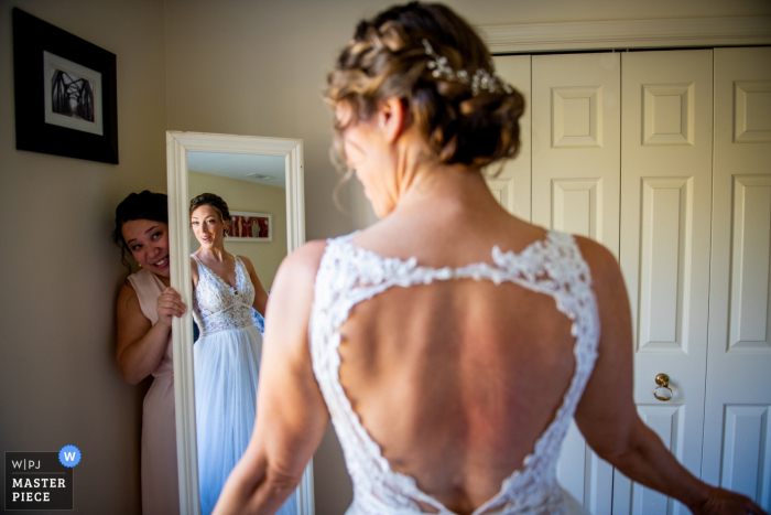 Fotografia de casamento na Virginia Farm, da dama de honra segurando o espelho para que a noiva possa dar uma boa olhada em si mesma antes de sair para olhar pela primeira vez.