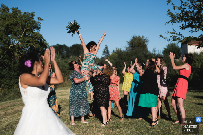 Fotografia de casamento em Andiran, França, da recepção ao ar livre do buquê de flores para as mulheres