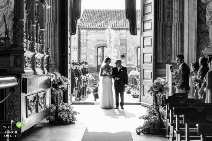 Italy wedding image captured of the bride's father as he freezes at the church entrance and their gazes meet for an intimate moment at the Basilica di Santa Caterina Alessandrina