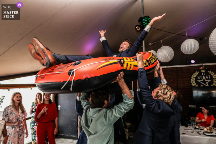 Fotografía de boda en la playa de Scheveningen que muestra la fiesta de recepción, el novio en el barco del amor