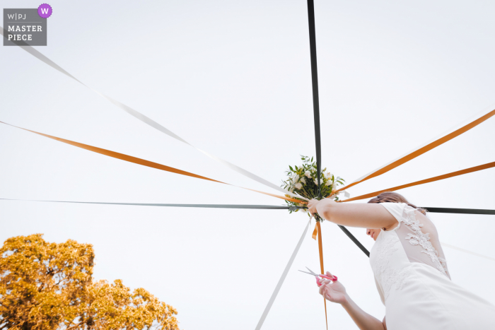 Les Cabanes dans les Bois Domaine de Fourtou wedding photography of the bouquet and ribbon cutting ceremony outdoors