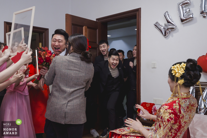 Fotografia de casamento na China de uma casa de Fujian enquanto eles jogam jogos de porta para atrair a noiva