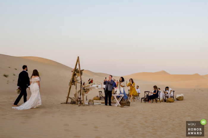 UAE wedding photo from a Dubai Desert Location showing the Bride and Groom returning to the Party in the sand