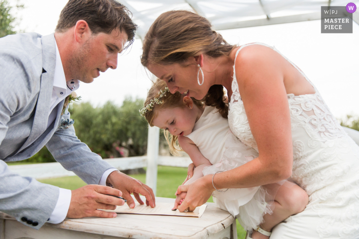 Cérémonie Laïque wedding photo of the Finger Signing of the marriage certificate for a child