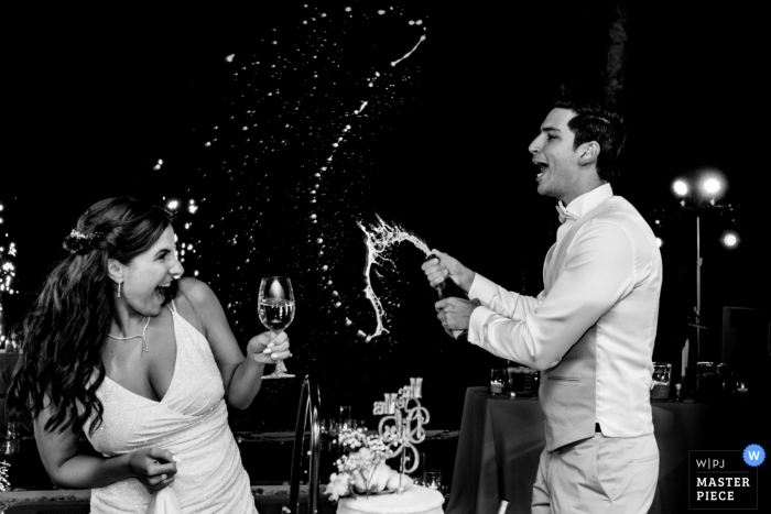 Nikki Beach Dubai wedding photography showing the Splashing of the Champagne on the Bride Nikki Beach Dubai wedding photography showing the Splashing of the Champagne on the Bride