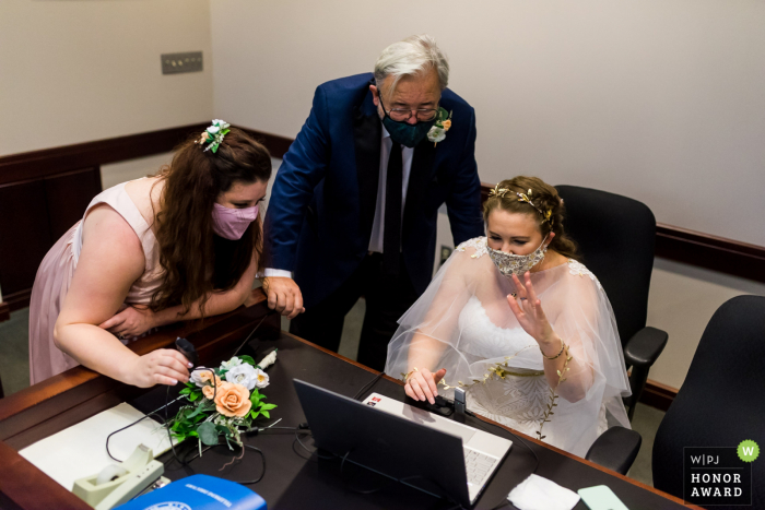 Texas wedding photography from the 2nd District Court of Appeals, Fort Worth showing A bride waving to her friends and extended family members on zoom after her civil ceremony