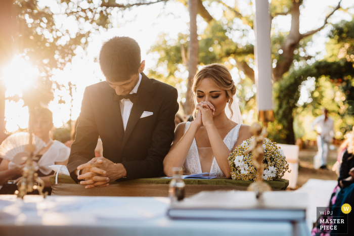 Fotografía de la boda de la ceremonia de Apulia de la ceremonia al aire libre bajo el sol de la tarde bajo los árboles