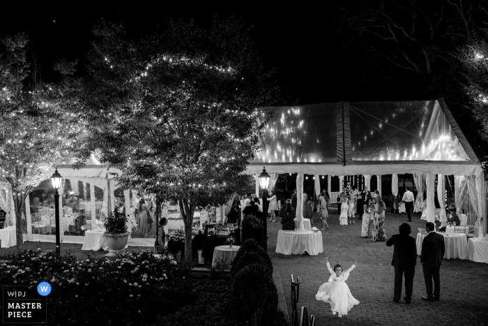 De huwelijksfotografie van de receptie in Pennsylvania van het bloemenmeisje dat de tijd van haar leven heeft terwijl het receptiefeest zonder haar doorgaat