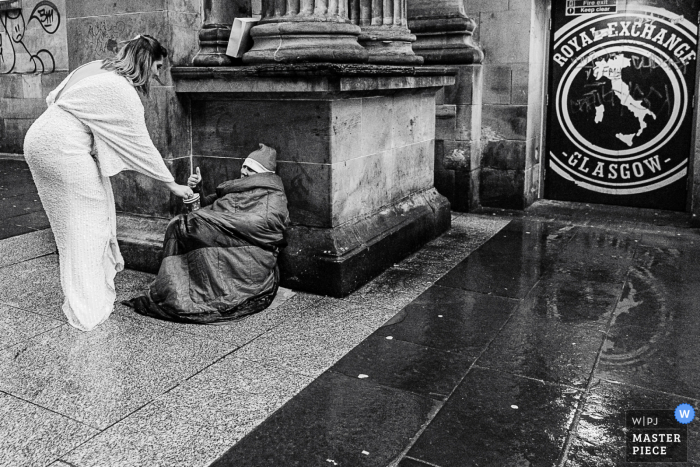 Glasgow City Centre wedding photo showing the bride being kind and giving help Glasgow City Centre wedding photo showing the bride being kind and giving help