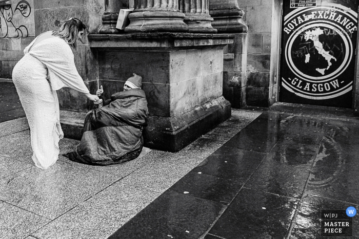 Foto de casamento no centro da cidade de Glasgow mostrando a noiva sendo gentil e ajudando