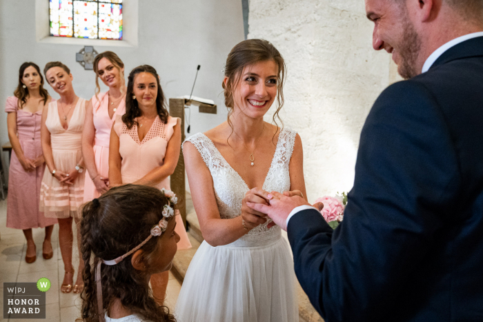 Französische Hochzeitsfotografie von Rembouillet, die die Braut zeigt, die den Ring auf den Finger des Bräutigams legt