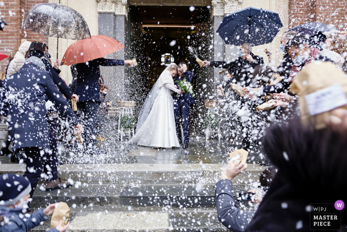 Basilica di San Magno, Legnano, Italia foto di matrimonio che mostra una tempesta di riso sugli sposi