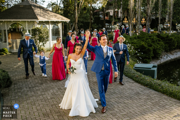 Castelo Saint Andrews, Gramado, Brasil Fotografia de casamento mostrando a noiva e o noivo celebrando como noivos com todos os convidados juntos