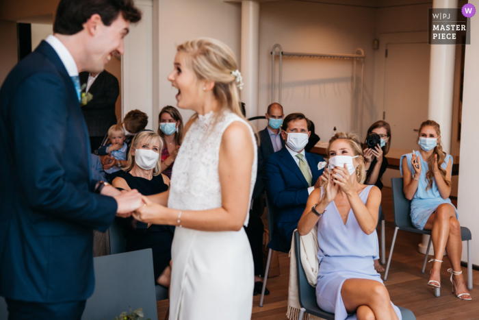 Foto de boda en el ayuntamiento de Flandes que muestra a la gente animando cuando la pareja se dice "Sí, quiero"