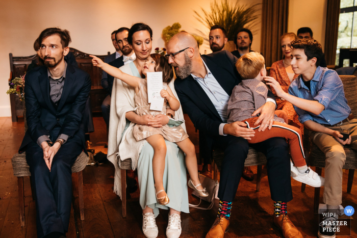 Fotografía de la boda de la recepción de Flandes que muestra a los niños jugando durante la ceremonia