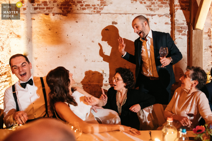 Fotografia de casamento para recepção na Flandres criada como Um amigo do noivo está contando uma piada