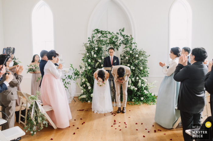 Foto de casamento em Milton Ridge, Maryland mostrando Os noivos estão fazendo uma promessa perfeita de 90 graus aos convidados para mostrar seu respeito por sua presença durante a pandemia