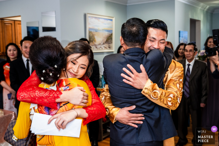 Virginia Home Ceremony wedding photography of the The Bride and Groom hugging their parents in tea ceremony