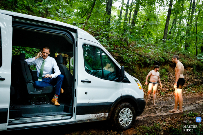 Hochzeitsfotografie aus North Carolina aus Asheville, NC von Der Bräutigam fordert einen Abschleppwagen, während seine Trauzeugen versuchen, einen Weg für den Van zu finden