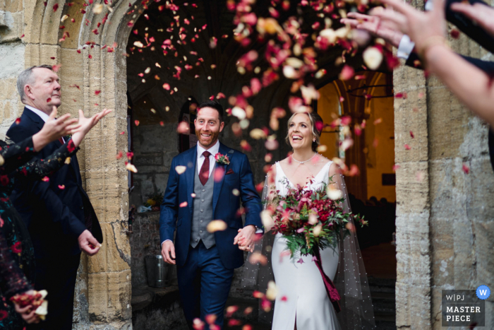 UK Hochzeitsfoto von einem Paar, das aus einer Kirche in Wiltshire, England herauskommt