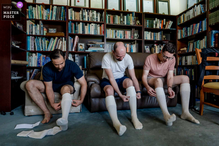 Eine Hochzeitsfotografin in Nar Nar Goon, Victoria, hat dieses Bild von Trauzeugen in Australien kreiert, die sich bereit machen, hohe, lange Socken anzuziehen