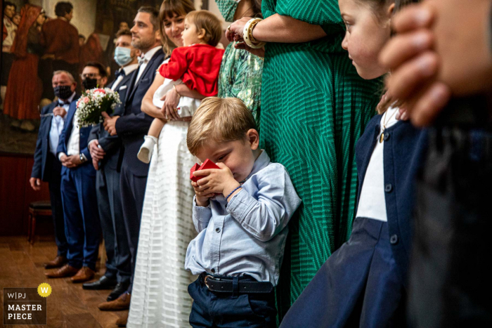 A top wedding photographer in Occitanie captured this picture of A child monitoring rings at the City hall during the marriage ceremony