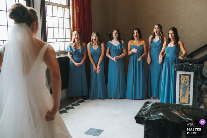 A Cleveland wedding photographer in Ohio created this image of the First look reaction of the bridesmaid of bride in her gown