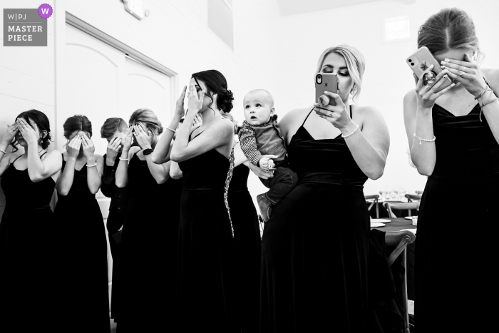 Un fotógrafo de bodas de primer nivel en Spring, Texas capturó esta imagen en el lugar de bodas y eventos de Addison Woods del primer vistazo de las novias con las damas de honor y el portador del anillo.