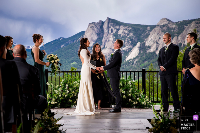 La mejor fotografía de bodas de Black Canyon Inn de Estes Park, CO que muestra una foto de una ceremonia rústica al aire libre en una montaña