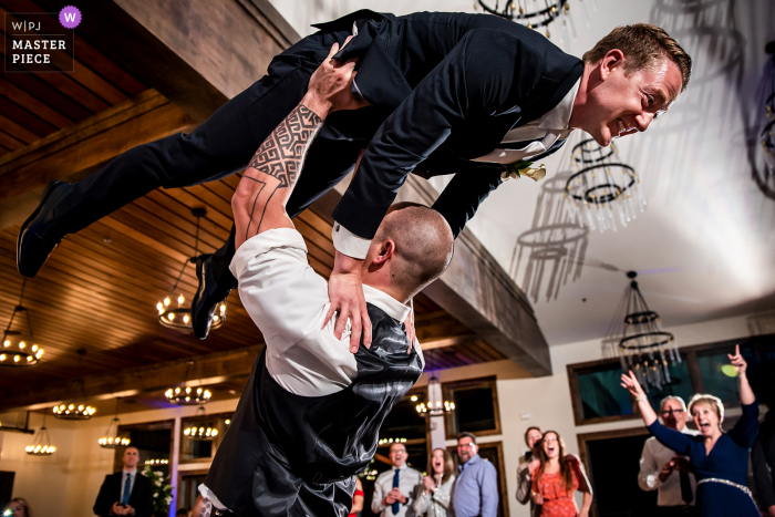 Un photographe de mariage de Boulder au Black Canyon Inn à Estes Park a créé cette image d'un homme d'honneur du Colorado soulevant le marié dans les airs