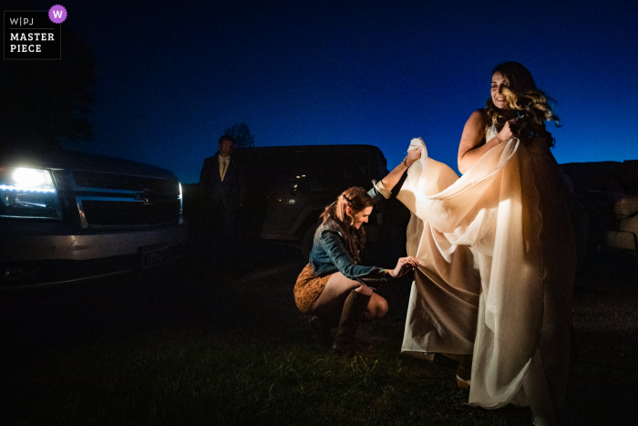 Best wedding photography from Emigrant, Montana showing a pic of bustling the dress by headlights Best wedding photography from Emigrant, Montana showing a pic of bustling the dress by headlights