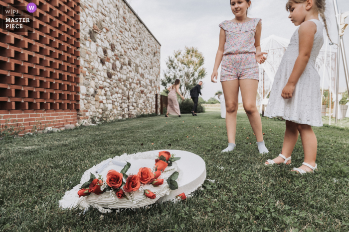 Ein italienischer Hochzeitsfotograf in Venedig hat dieses Bild von schockierten Kindern geschaffen, die die heruntergefallene Hochzeitstorte betrachten, während im Hintergrund die wütende Brautjungfer den Verantwortlichen anschreit