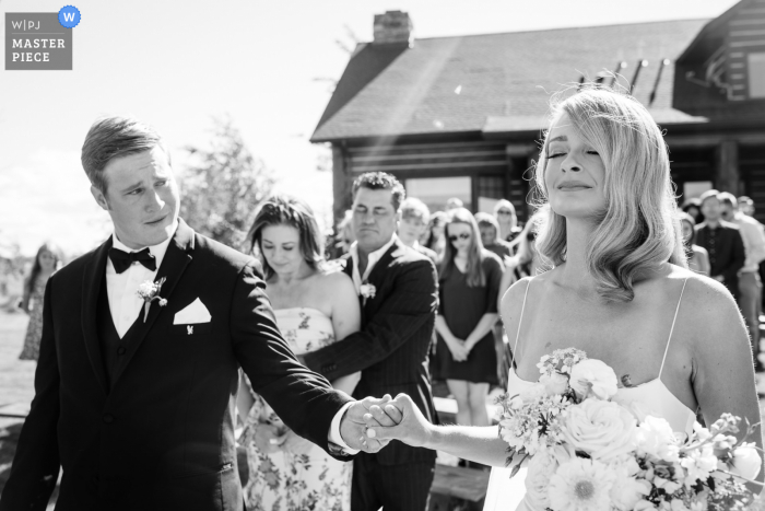 A top wedding photographer in Belgrade, Montana captured this picture of a groom sneaking a look during prayer