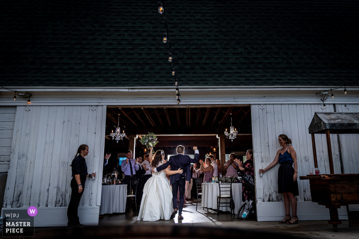 Um fotógrafo de casamento de Illinois na Fazenda Ashley em Yorkville criou esta imagem do casal sendo apresentado ao entrar no celeiro