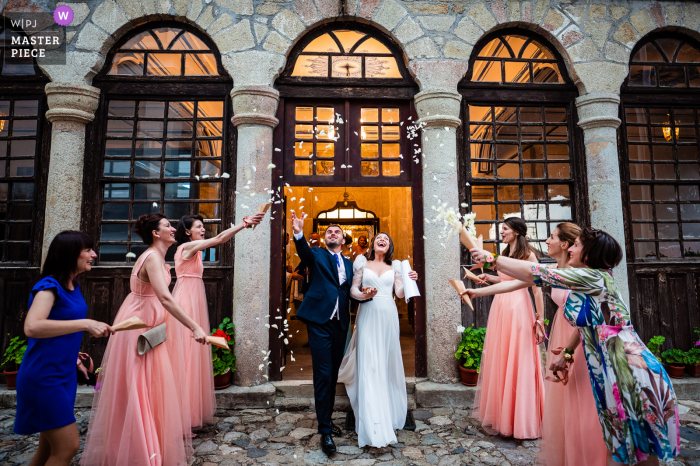 A top Ruse wedding photographer captured this picture of the bride and groom leaving under a confetti shower by bridesmaids