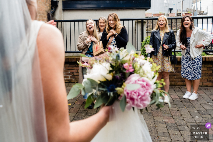 Een topfotograaf voor trouwreportages in Dublin, Ierland maakte deze foto van Vrienden die buiten stonden te wachten tijdens de ceremonie om de bruid te feliciteren