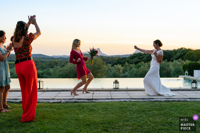 A French wedding photographer at Mas Saint Germain created this image showing The witness caught the bouquet from the brides toss 