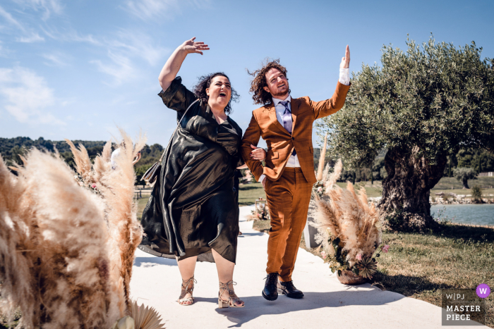 Les Domaines de Patras melhor fotografia de casamento de Solerieux mostrando uma foto de um irmão e uma tia se aproximando do corredor da cerimônia ao ar livre