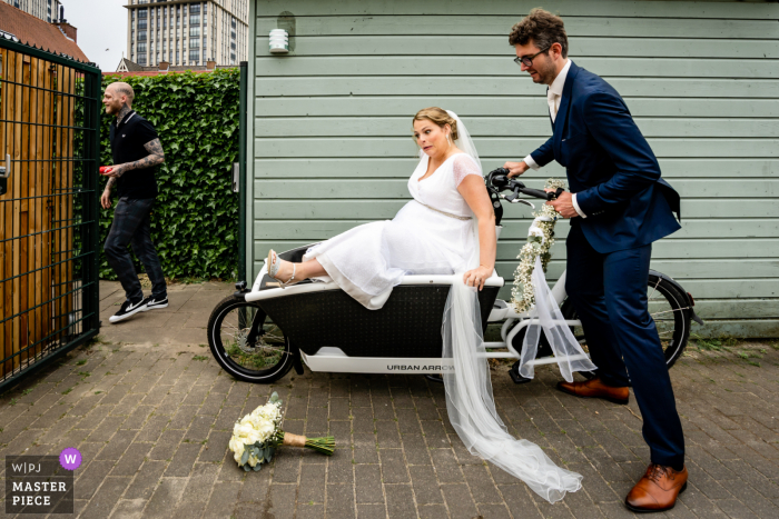 Een top trouwfotograaf in Maassluis maakte deze foto van de bruid die zich klaarmaakt voor haar ritje op de fiets met de bruidegom