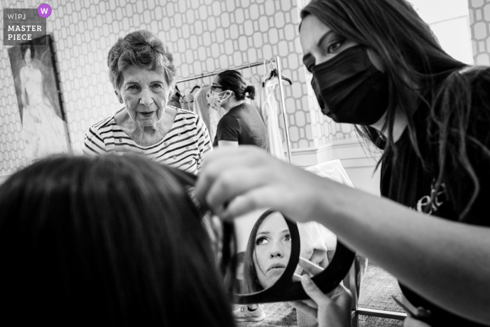 A wedding photographer at a Pennsylvania hotel created this image of Bride getting her touch ups done under the close eye of her grandma