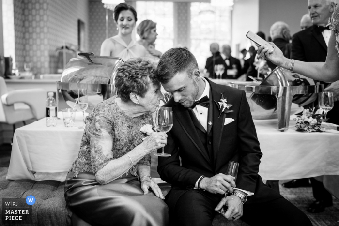 Best wedding photography from PA showing a pic taken Immediately after the ceremony concluded as brides grandma pulled the groom over to give him some marriage advice and tips 