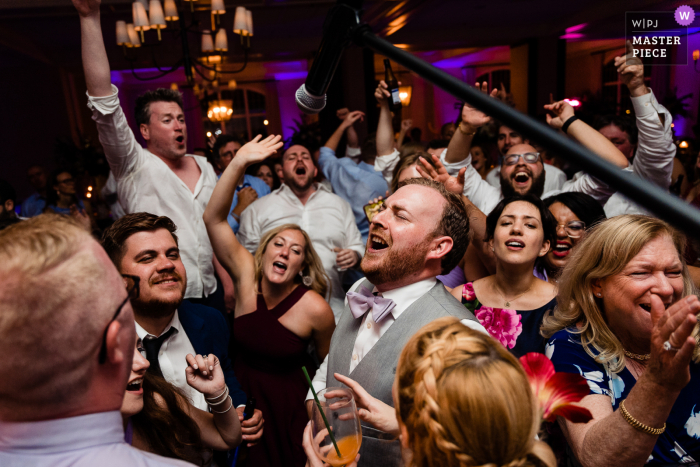 Ein Top-Hochzeitsfotograf in Pennsylvania hat dieses Bild des Bräutigams aufgenommen, der den Chor beim Singen mit der Band anführt