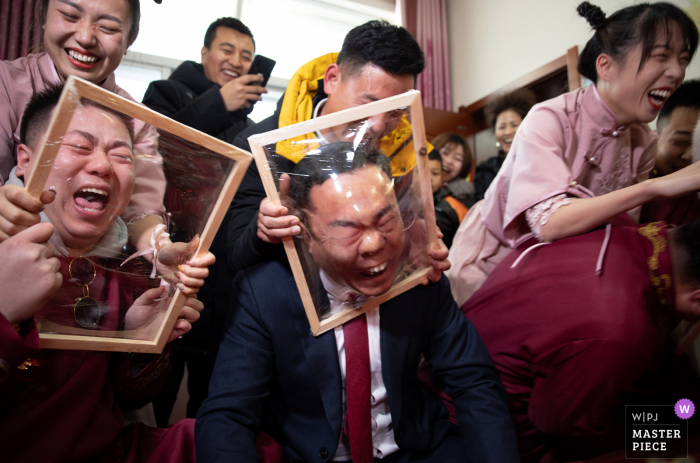 Een trouwfotograaf in Shaanxi heeft deze afbeelding van het deurhuwelijksspel gemaakt met gespannen plastic over houten frames